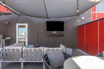A patio with a white canopy and grey couches.